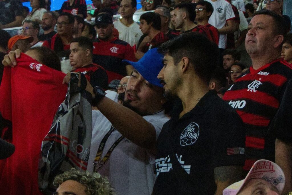 Torcedores do Flamengo com camisas e bandeiras rubro-negras vibrando na arquibancada do Maracanã